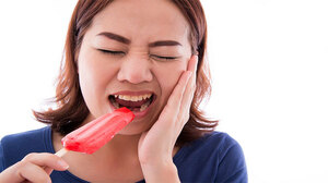 Woman with tooth pain from a cold treat